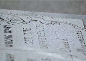 Close-up of granite memorial craftsmanship with detailed etching work
