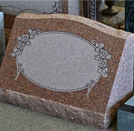 Granite slant marker with custom etching on cemetery foundation